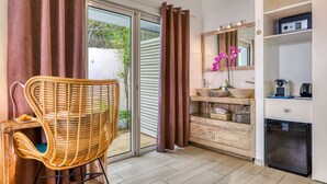 Um banheiro moderno com porta de vidro para uma varanda, uma cadeira de vime, um espelho com bancada de madeira e uma pia embutida.