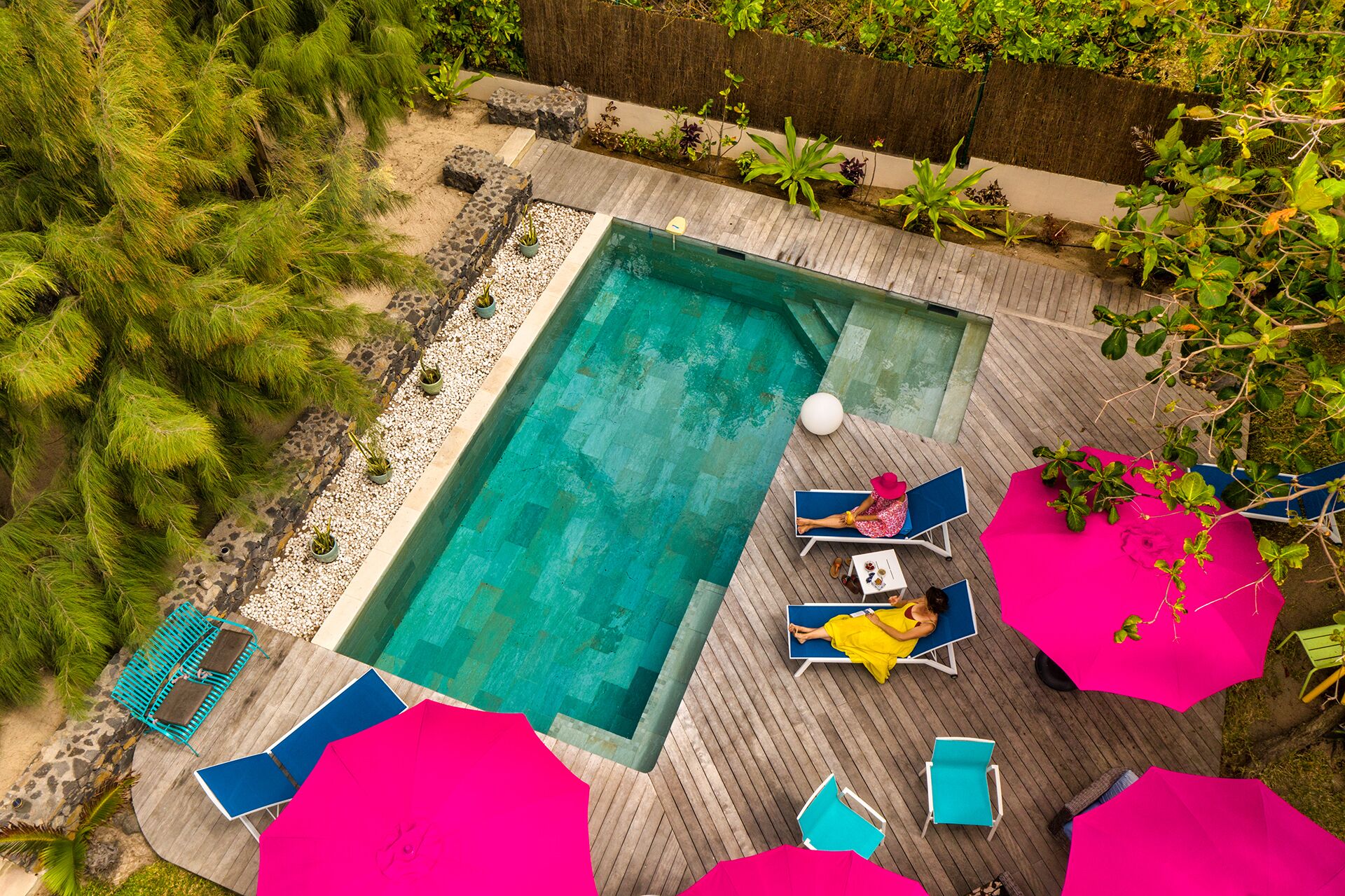 Una piscina al aire libre, sombrillas, tumbonas