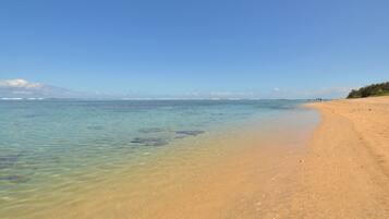 On the beach, white sand, sun loungers, beach umbrellas