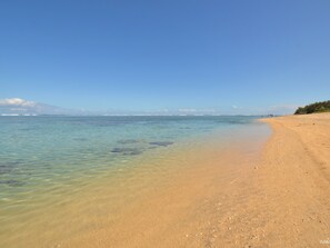 On the beach, white sand, sun loungers, beach umbrellas