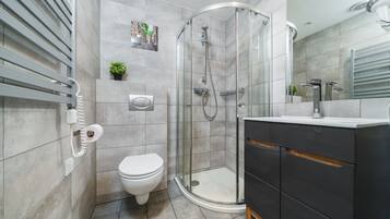 Studio (2 Orchid) | Badkamer | Een douche, een haardroger, handdoeken