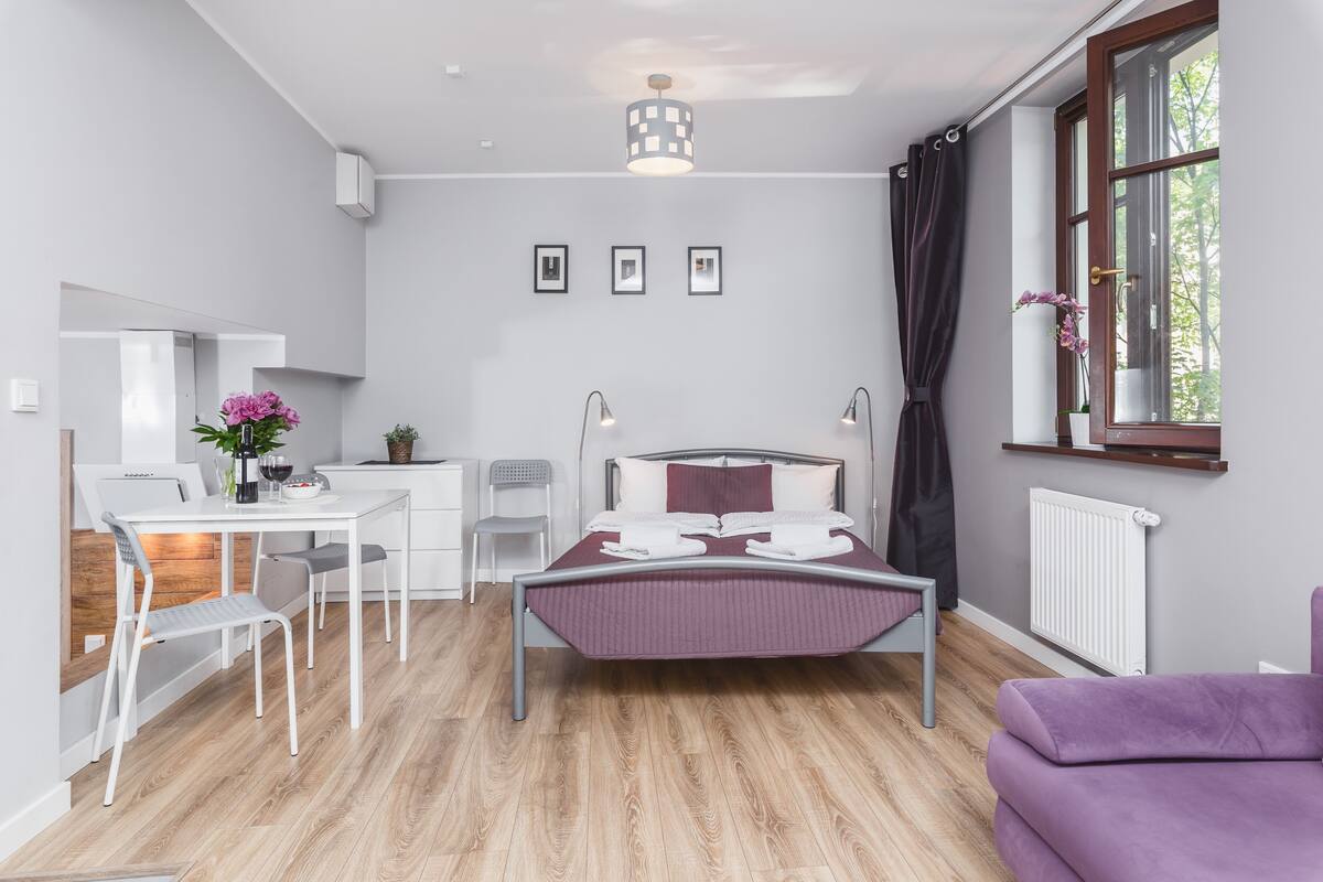 Une chambre à coucher moderne avec un lit, des tables de chevet, un bureau et une chaise.