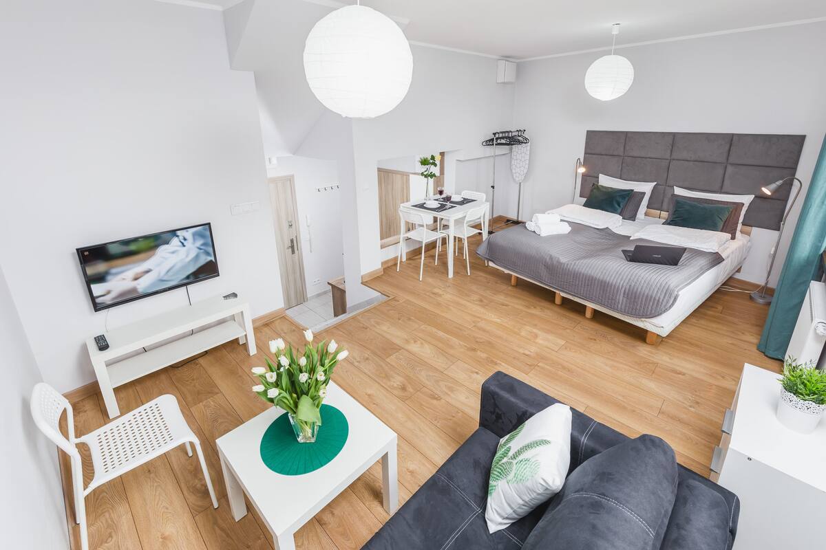 Une chambre d’hôtel moderne équipée d’un lit, d’un canapé, d’un coin repas et d’une télévision.