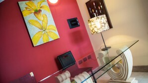 Un muro rosso con un dipinto floreale, una lampada moderna e una ringhiera in vetro.