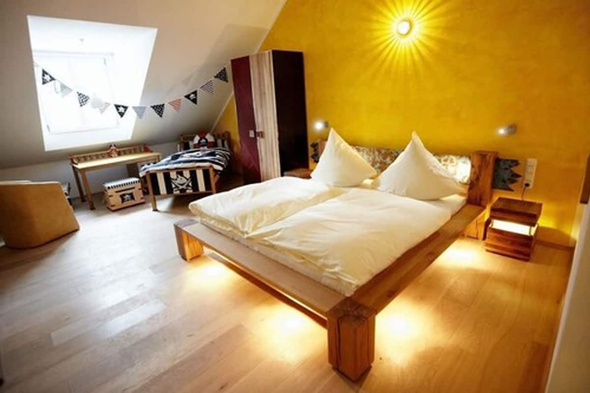 Une chambre avec un lit en bois, un bureau et une fenêtre donnant sur un beau paysage.