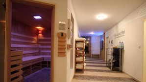 A hallway with a sauna area, a towel rack, and a bar area with a sign. - Residenz Schloss Engers (Neuwied)