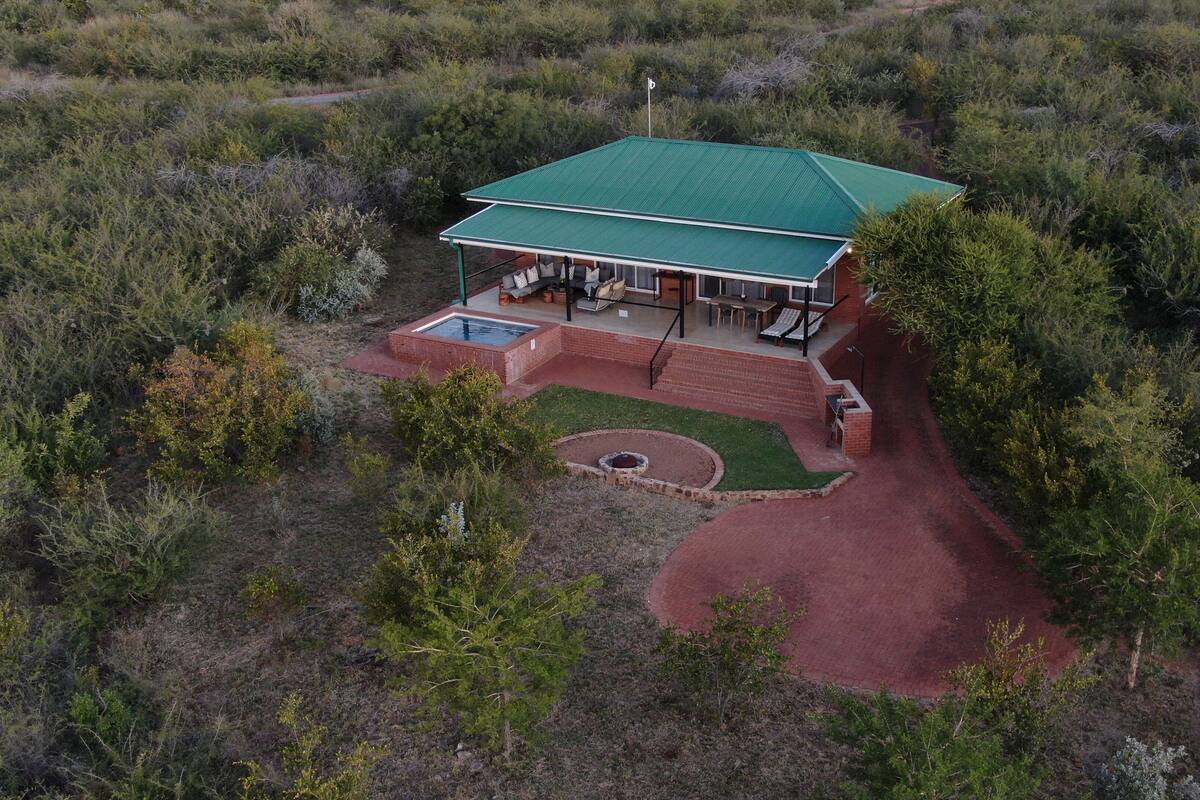 Een huis met een groen dak, een zwembad en een terras.