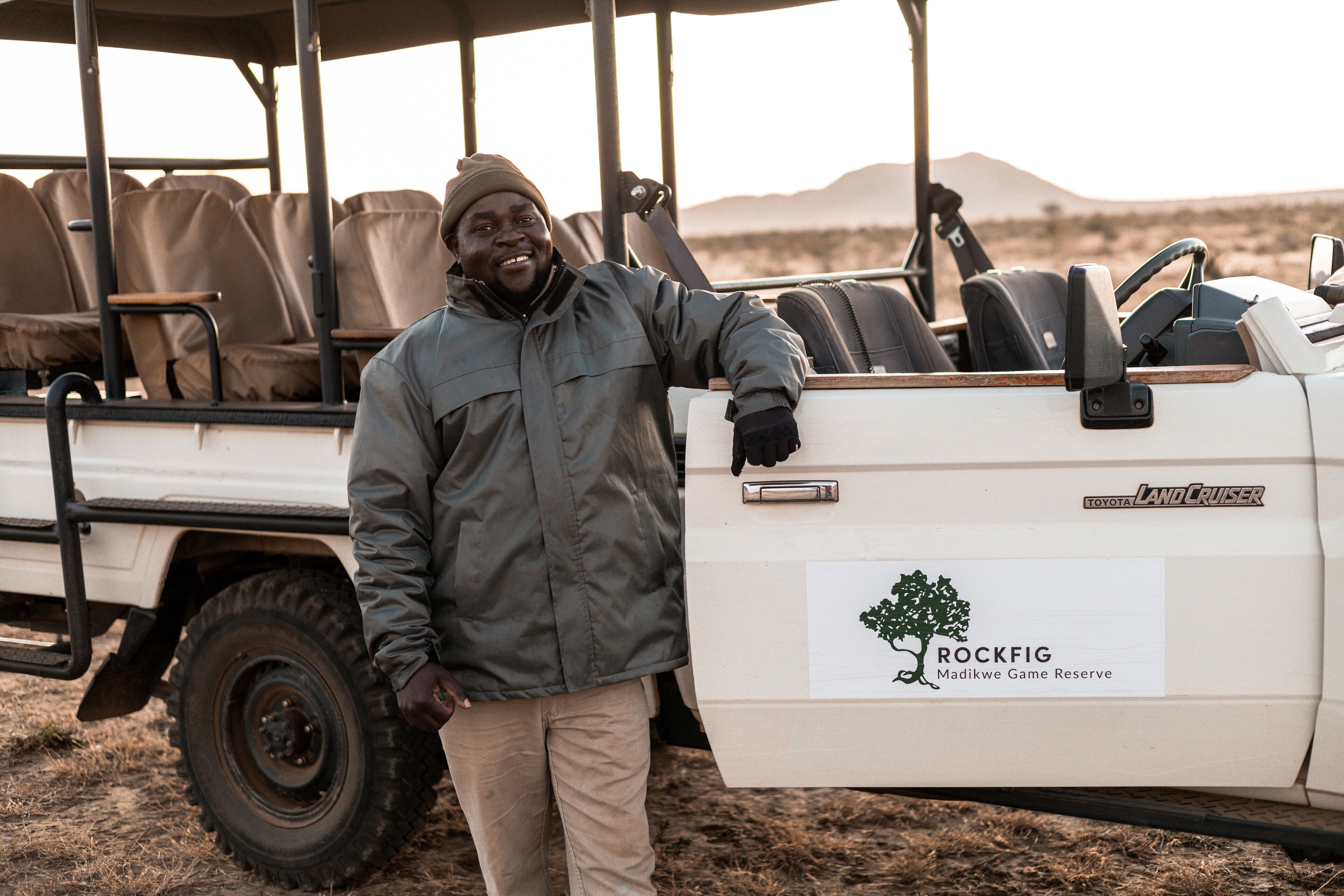 A vehicle with a logo for Toyota Land Cruiser and a sign for Rockfig Madikwe Game Reserve.