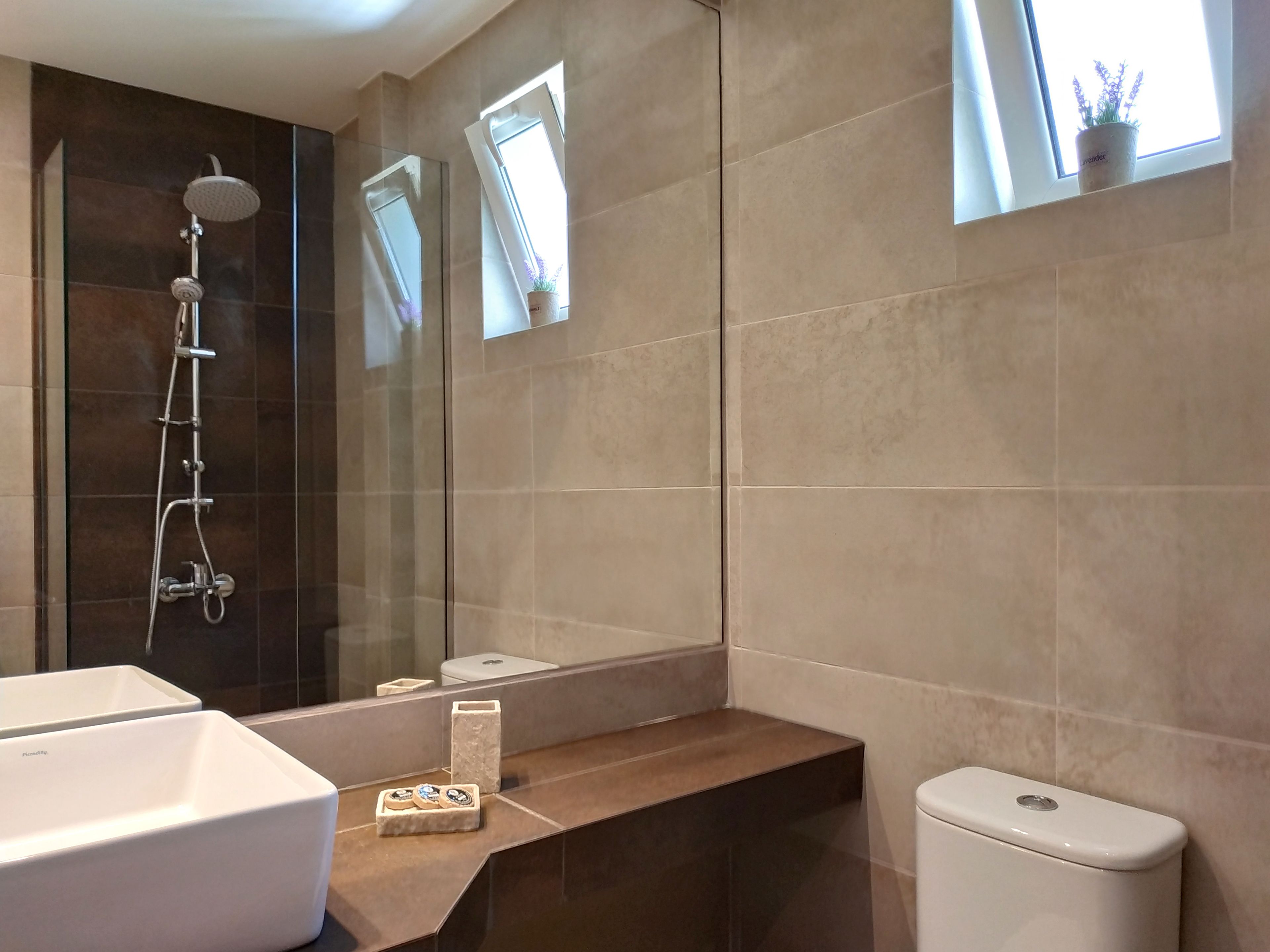Une salle de bain moderne équipée d’une douche, de toilettes et d’un lavabo.