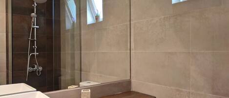 Une salle de bain moderne équipée d’une douche, de toilettes et d’un lavabo.