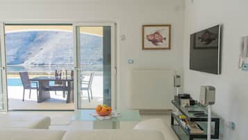 Villa, vista mare | Area soggiorno | TV a schermo piatto, caminetto