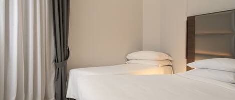 A modern hotel room with a large bed, a headboard, and a curtain.