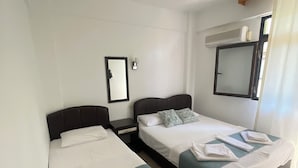 A hotel room with two beds, a ceiling fan, a mirror, and a window with curtains. - Anatolia Hotel Ozdere (Menderes)