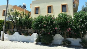 A two-story residential building with a flat roof, multiple windows, and a white exterior wall. - Anatolia Hotel Ozdere (Menderes)