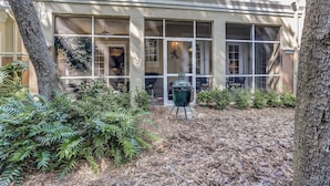 A building with large windows, a barbecue grill, and a well-maintained garden with various plants. - Exclusive Gated Villas at Summer Beach, Short Walk to the Beach by RedAwning (Fernandina Beach)