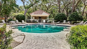 A swimming pool with lounge chairs, a gazebo, and surrounding trees. - Exclusive Gated Villas at Summer Beach, Short Walk to the Beach by RedAwning (Fernandina Beach)