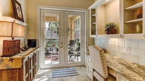 A kitchen with a marble countertop, a built-in oven, and a large window with a view of outdoor furniture. - Exclusive Gated Villas at Summer Beach, Short Walk to the Beach by RedAwning (Fernandina Beach)