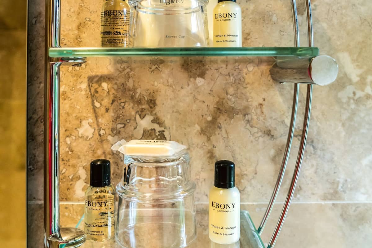 A bathroom shelf with glass jars and bottles, likely containing toiletries.