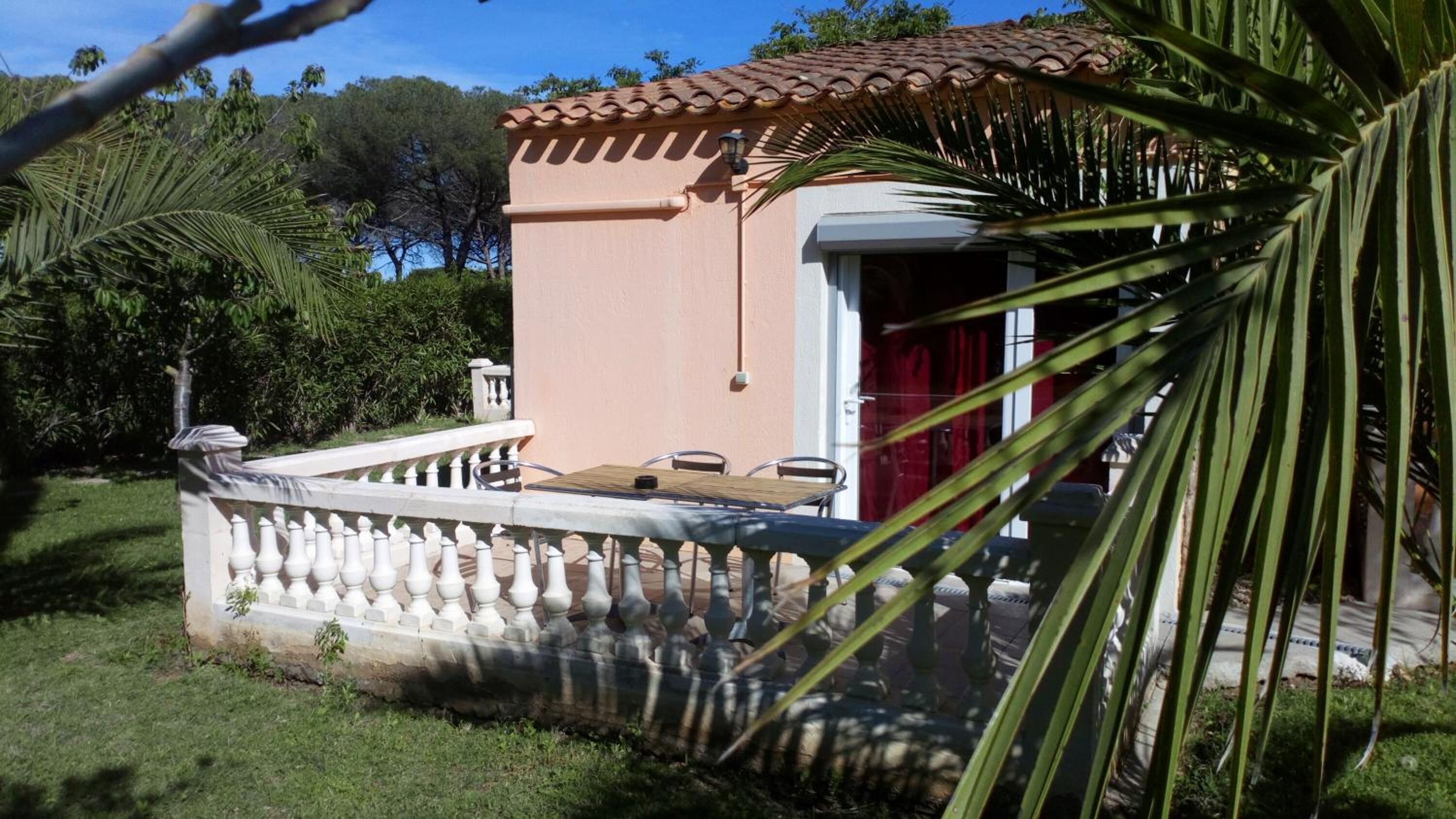 A small building with a tiled roof and a white balcony railing.
