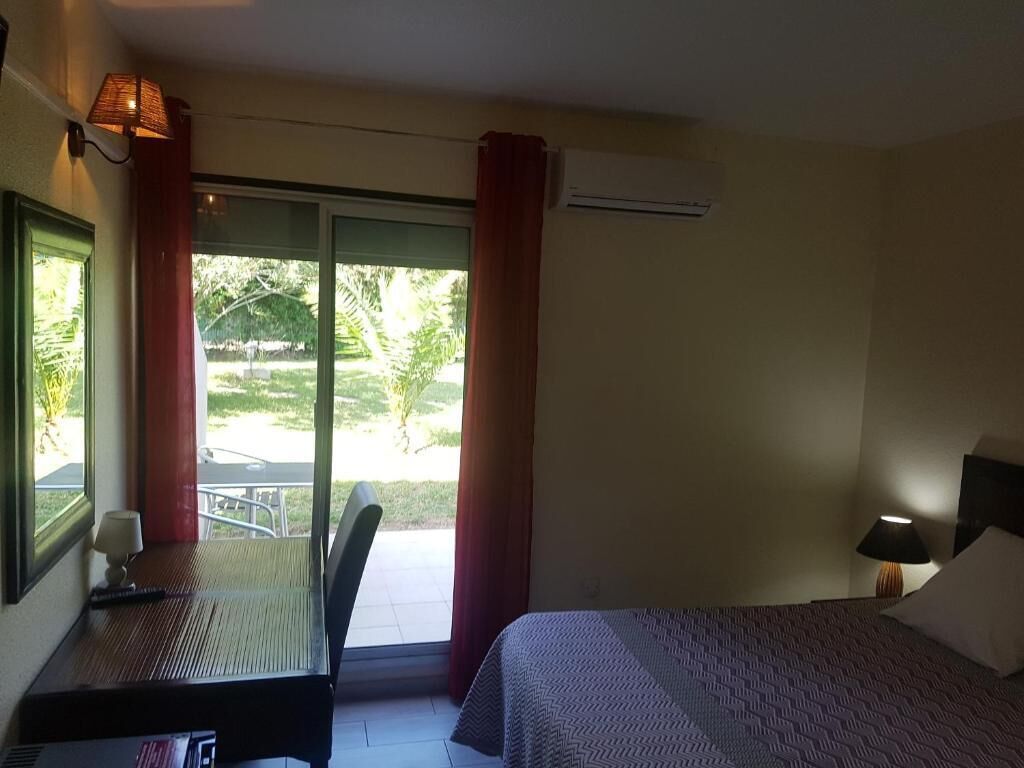 Una camera d'albergo con un letto, una scrivania, una sedia, un tavolo e vista sull'esterno.