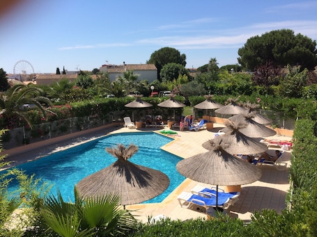 Seasonal outdoor pool, open 10:00 AM to 8:00 PM, pool umbrellas. Brit Hotel Confort Helios Agde