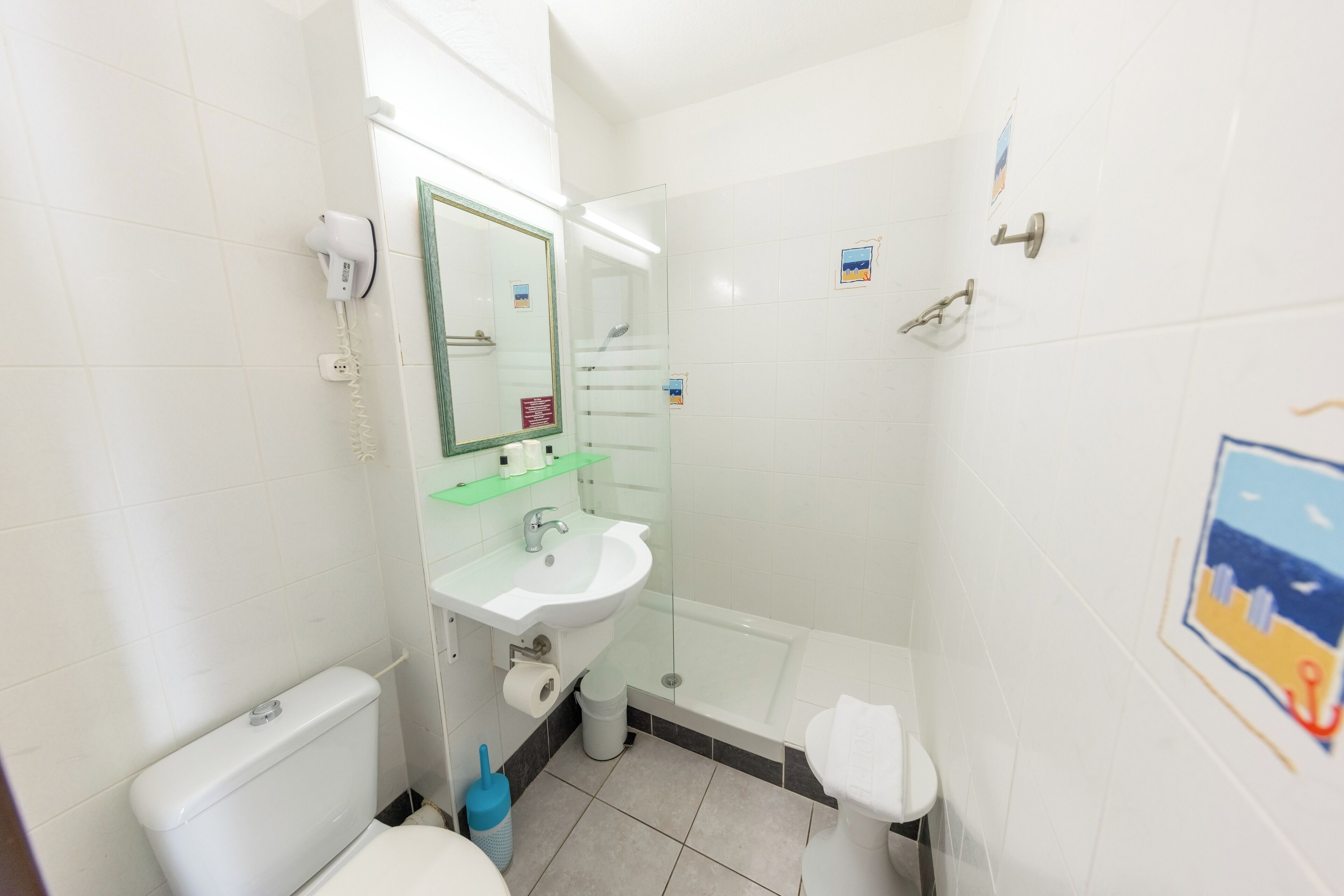A bathroom with a toilet, sink, and shower.