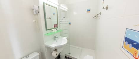 Een badkamer met toilet, wastafel en douche.