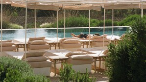 A poolside area with lounge chairs and a canopy.