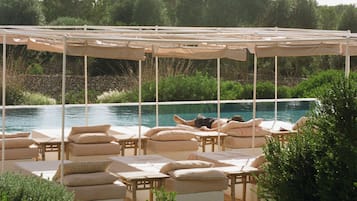 Alberca al aire libre, sombrillas en la alberca y camastros