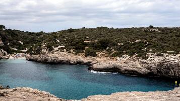 Un paysage côtier caractérisé par un terrain rocheux et une mer d’un bleu limpide.
