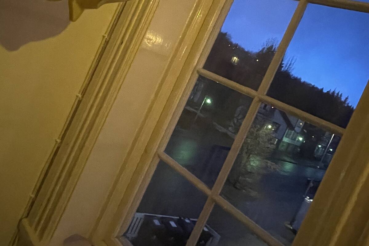 A window with a view of a street at dusk.