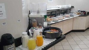 A buffet setup with various food items and beverages. - Villa Verde Hotel (Navirai)