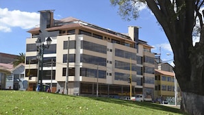 Un edificio de varios pisos con un diseño arquitectónico moderno, con grandes ventanales y techo plano.
