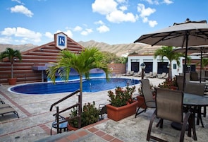 Uma área de piscina com espreguiçadeiras e uma placa indicando uma seção específica.