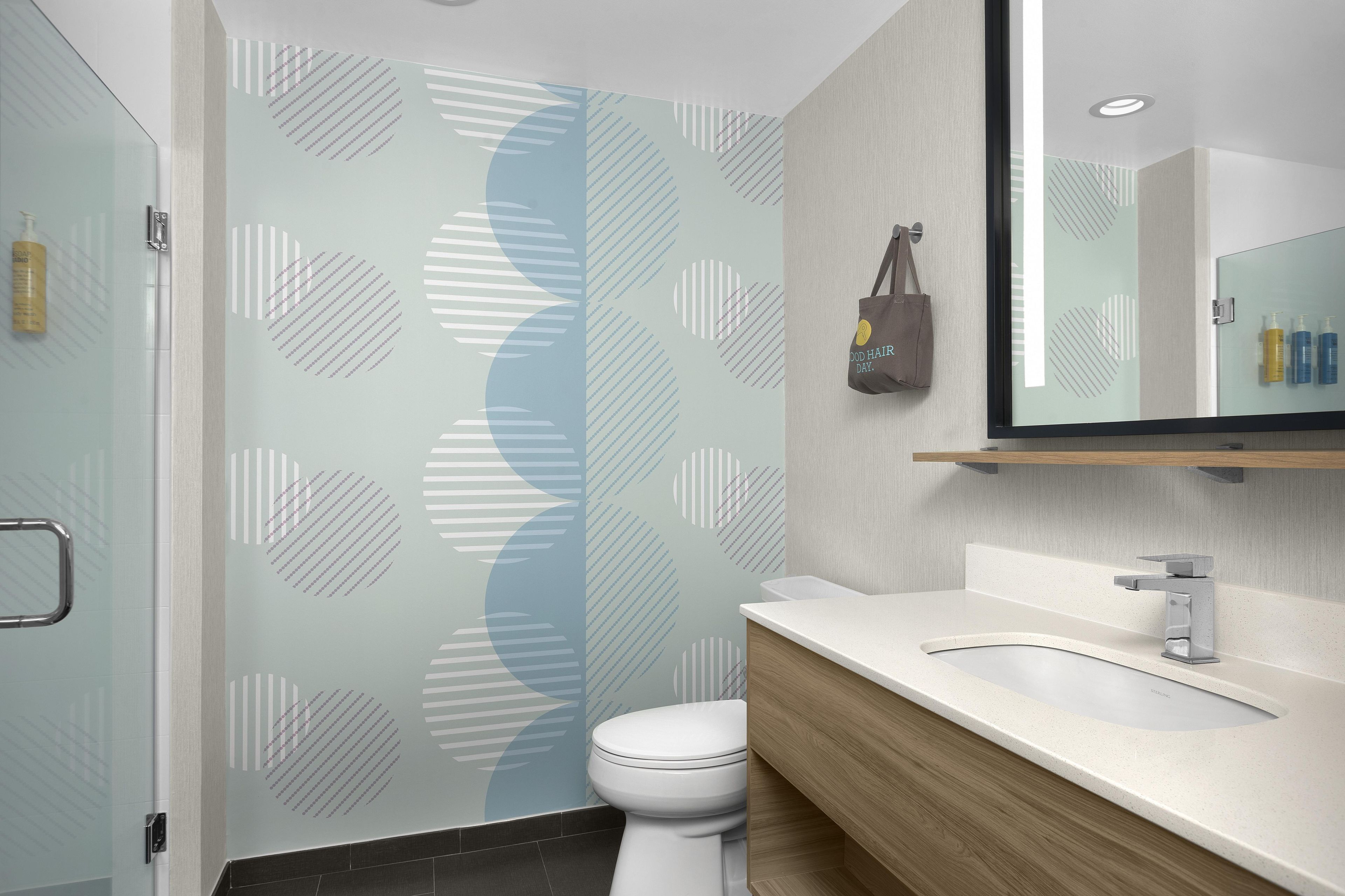 A modern bathroom with a shower, toilet, and vanity.