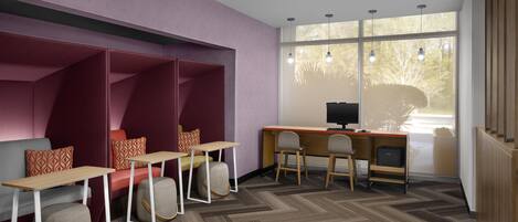 A modern office space with a desk, chairs, and a seating area with cushions.