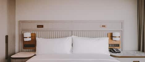 A hotel room with a bed, bedside tables, a telephone, and a nightstand.