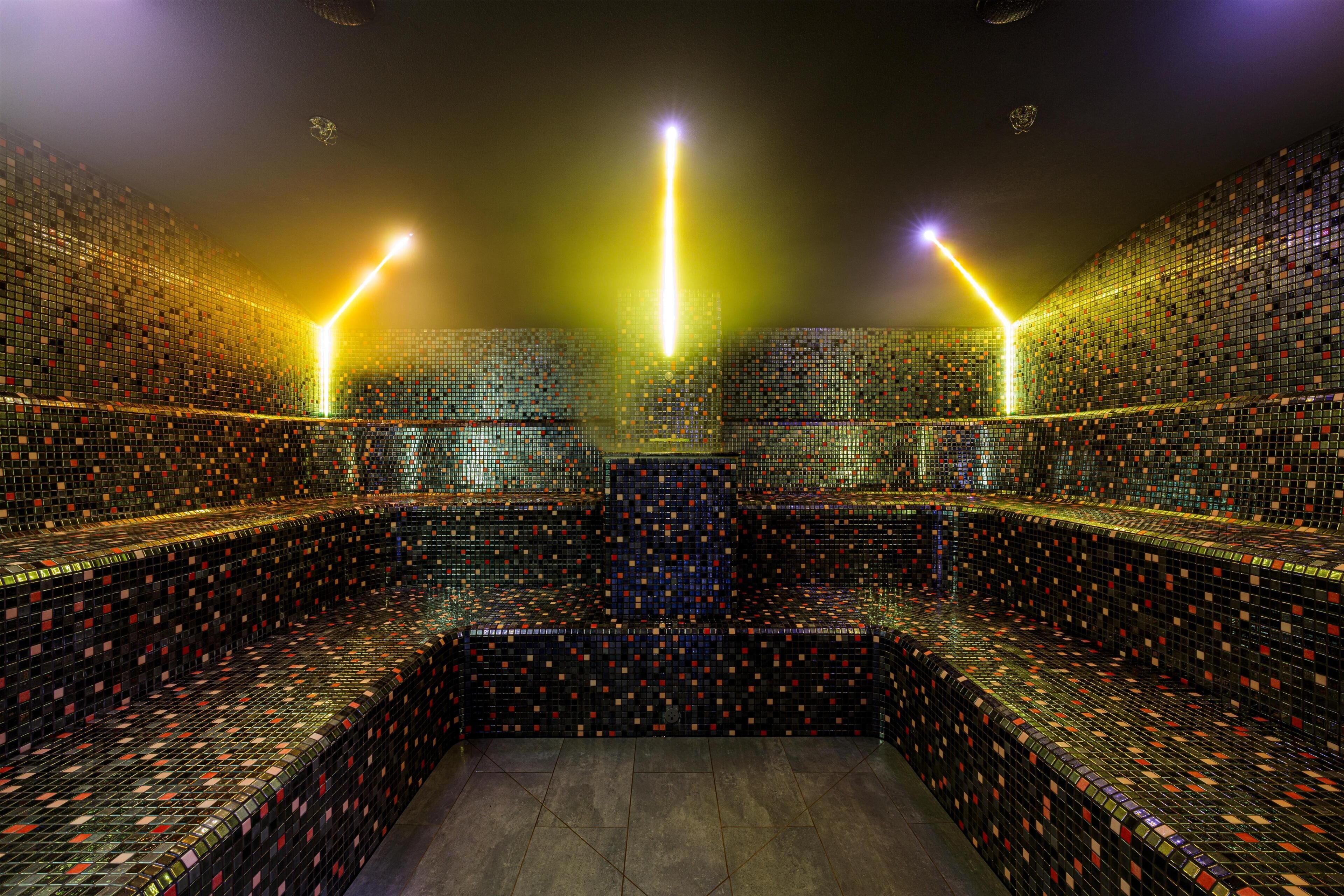 A room with a patterned floor, a central seating area, and a high ceiling.