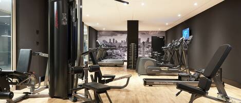 A modern gym with various exercise equipment, including weight machines, treadmills, and dumbbells.