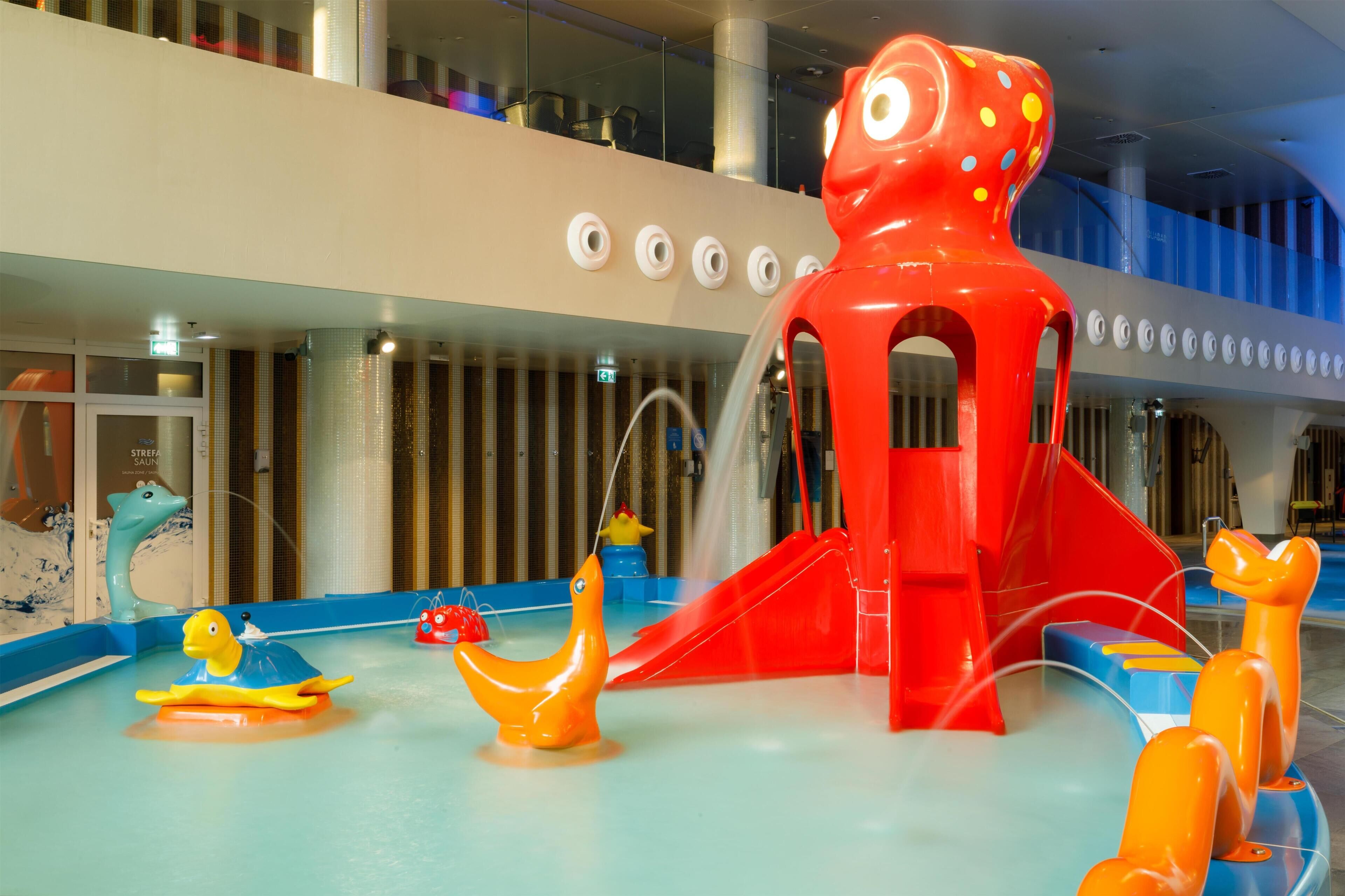 Un espace de jeux pour enfants avec des toboggans et des jeux d’eau.