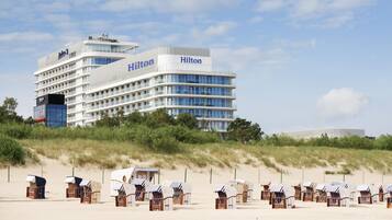 A multi-story hotel with a modern design, featuring balconies and large windows.