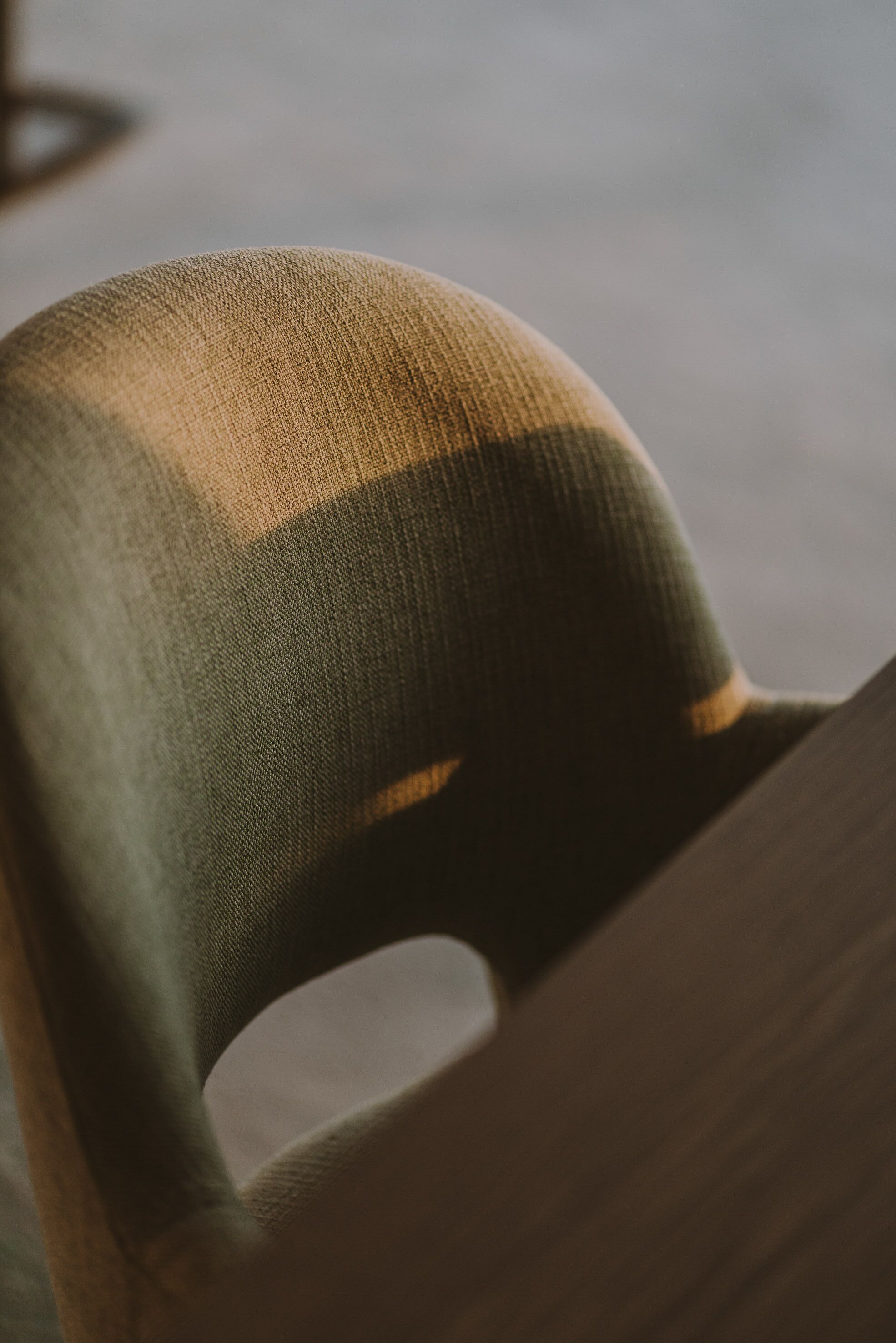 Un gros plan du dossier d’une chaise, dont le tissu présente une texture particulière.