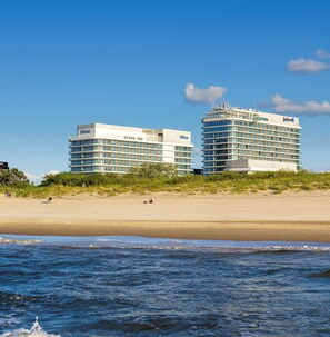 Twee moderne hotels met uitzicht op het strand, gelegen aan een zandstrand.