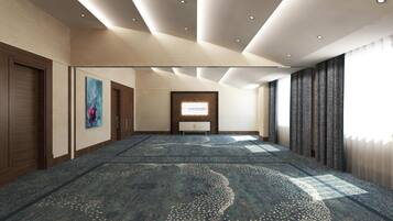 A spacious hotel lobby with a large carpeted area, a reception desk, and a wall-mounted sign.