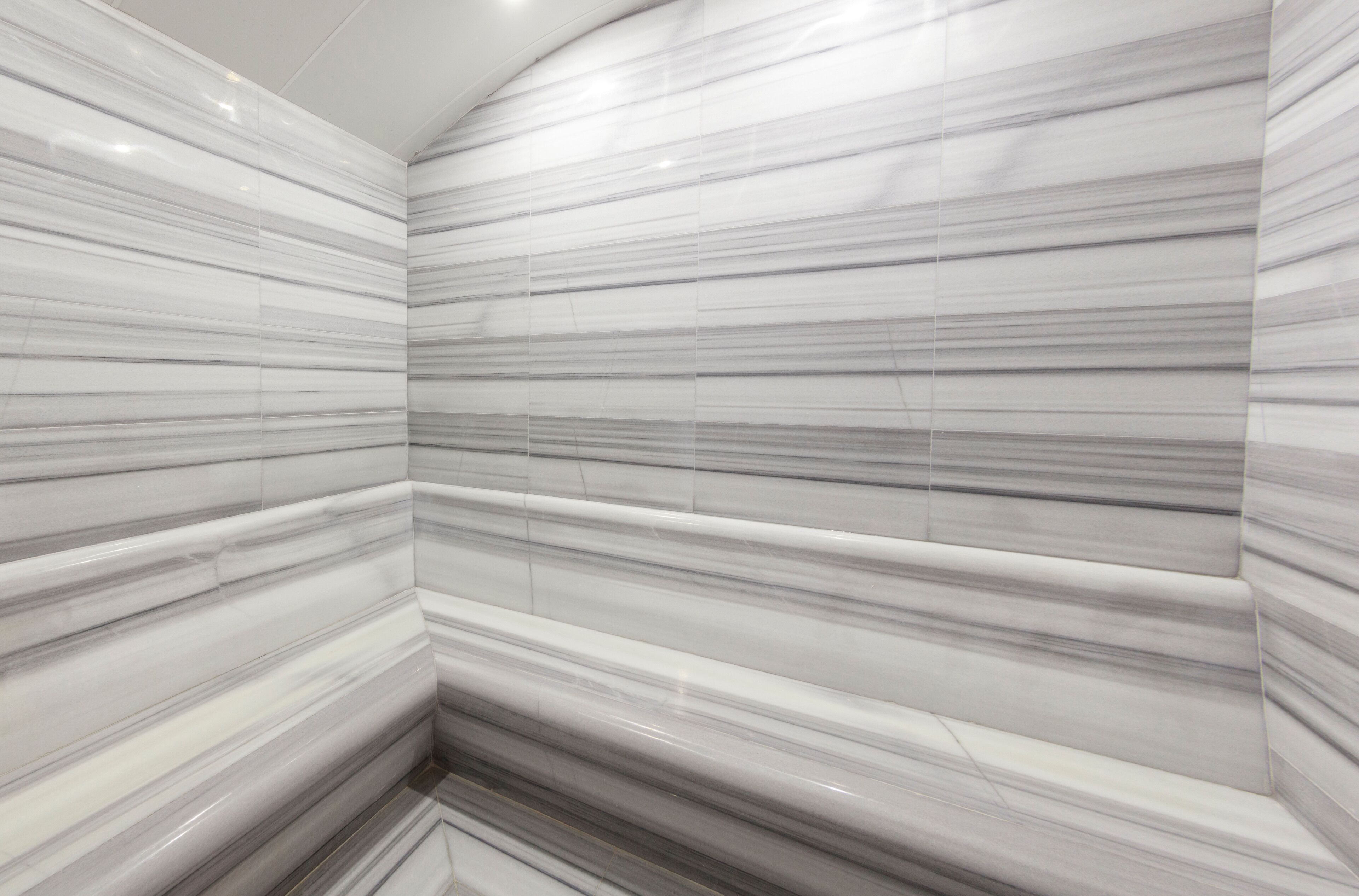 A bathroom with marble walls and a curved ceiling.