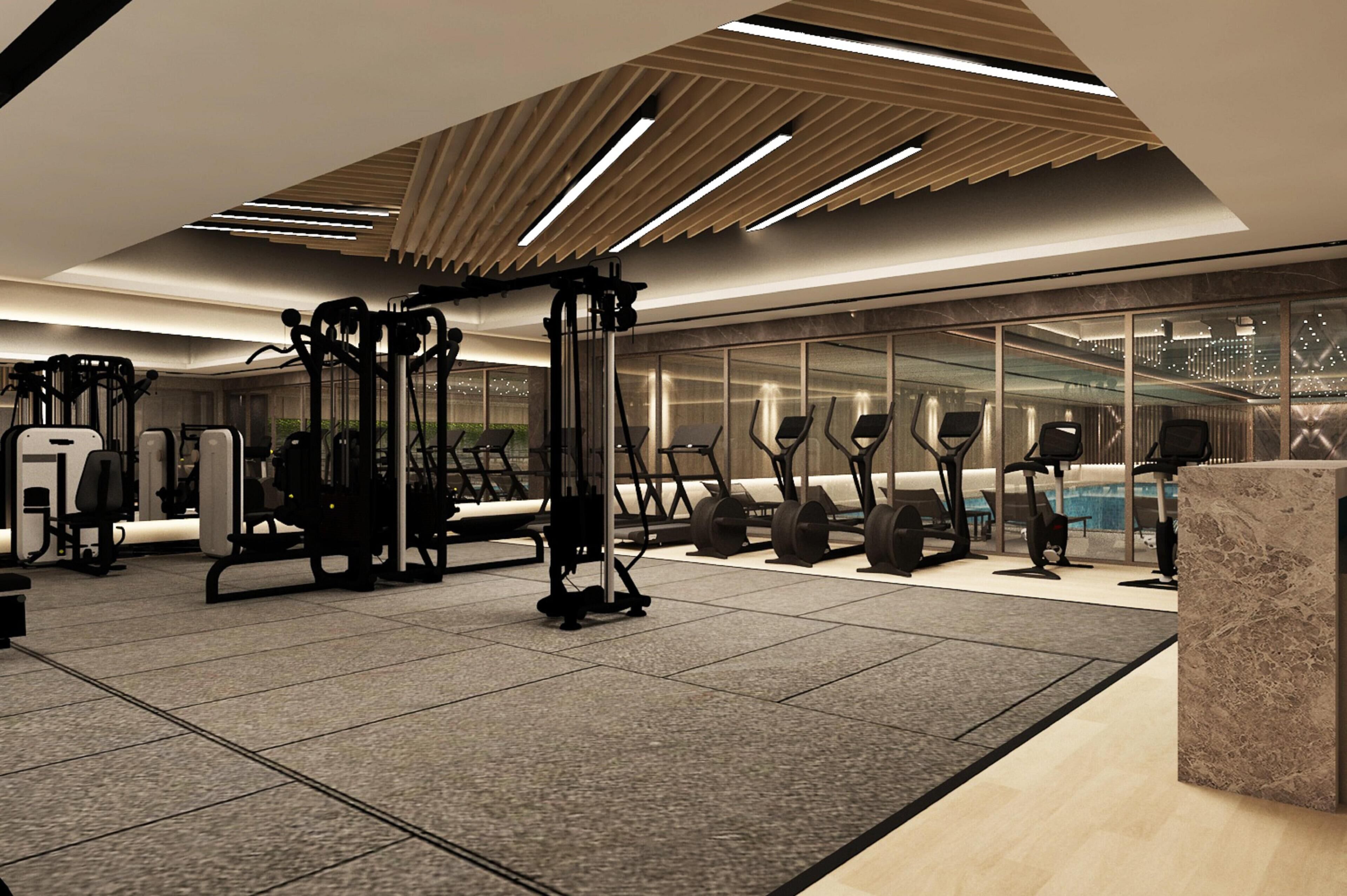 Un gimnasio moderno con equipo de ejercicio, un amplio ventanal y un pilar de mármol.