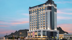 Un hotel moderno de gran altura, con amplios ventanales y vistas al agua.