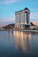 Un hotel moderno de gran altura, con amplios ventanales y vistas al agua.