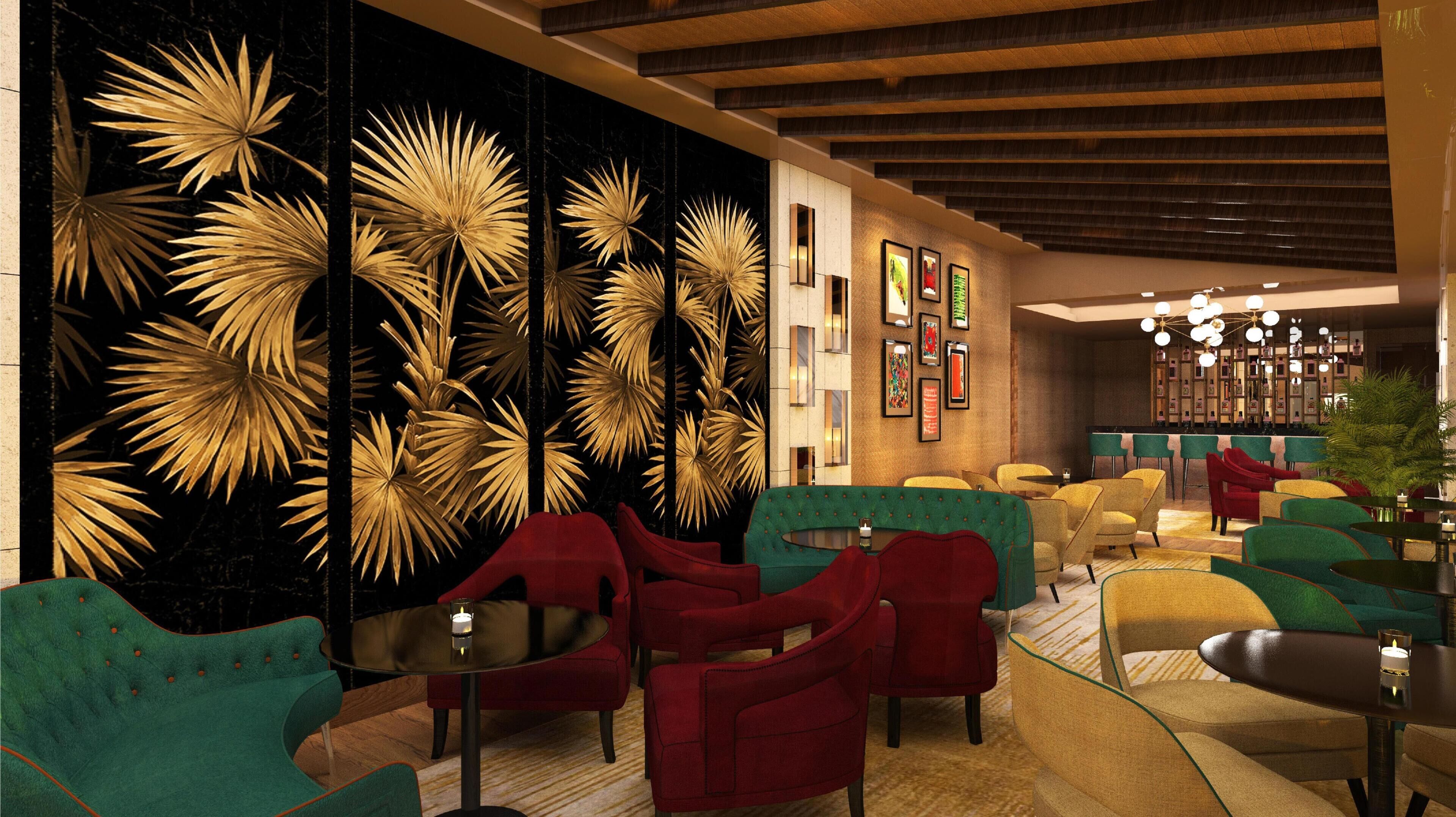 Un interior moderno con una pared de hojas de palma doradas, sillones tapizados en rojo y verde, y una zona de bar con candelabro.