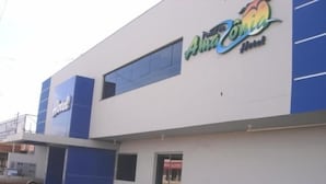 A building with a sign for "Alma Conia Hotel" and a smaller sign for "Hotel". - Hotel Portal da Amazônia (Varzea Grande)